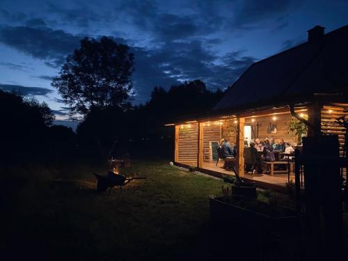 a group of people sitting outside of a cabin at night at Sielankowe Pole in Józefów