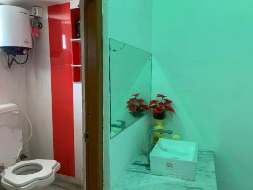 a bathroom with a toilet and a glass wall at Kolkata Sarkar Villa Homestay in Kolkata