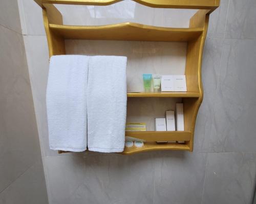 a towel rack with towels on it in a bathroom at Camphor Hotel in Ras al Khaimah