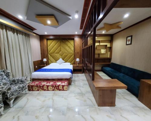a hotel room with a bed and a couch at Camphor Hotel in Ras al Khaimah