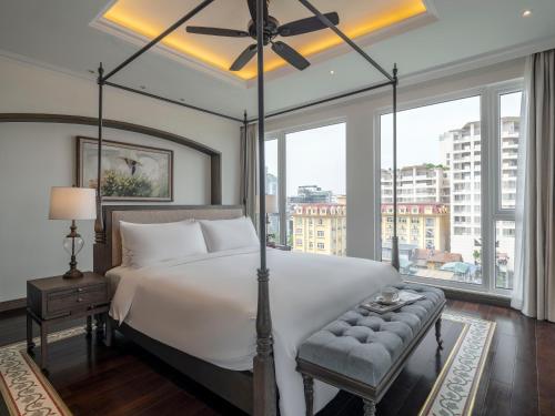 a bedroom with a large bed and a large window at De Syloia Hotel in Hanoi