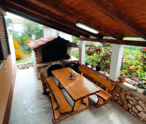 a patio with a wooden table and a stone oven at Apartments Josef - sea view in Veli Rat