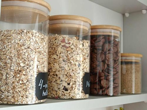 four jars of cereal and nuts on a shelf at Pärnu südalinna majutus in Pärnu