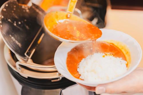 een persoon houdt een kom rijst vast bij Van Cort Landt Hotel in Aira