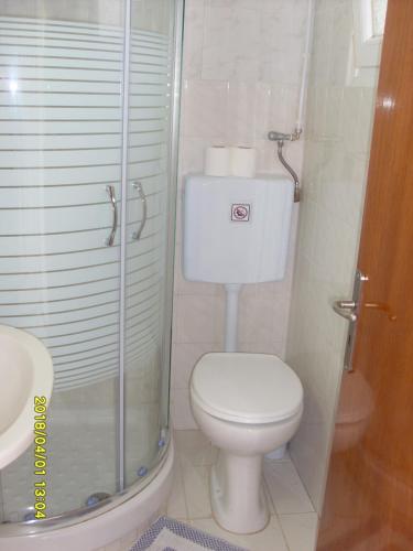 a small bathroom with a toilet and a shower at Angela Studios in Karfas