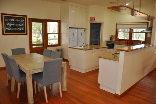 a kitchen with a wooden table and a dining room at Pokolbin Village Estate in Pokolbin