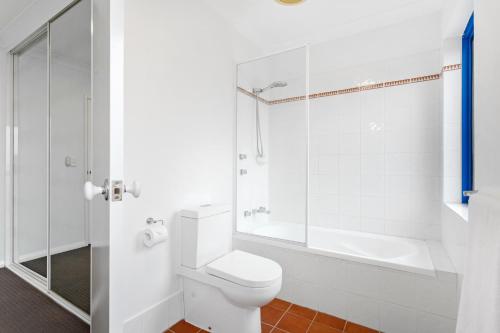 a white bathroom with a toilet and a shower at Nautica Residences Hillarys in Perth