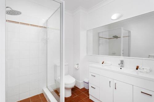 a white bathroom with a toilet and a sink at Nautica Residences Hillarys in Perth