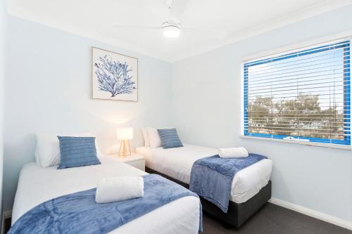 a bedroom with two beds and a window at Nautica Residences Hillarys in Perth
