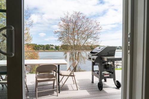 a grill on a patio with a view of the water at 40 - 4BR Lakeview - Lakeside retreat near GJK View in Yarmouth