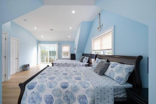 a bedroom with two beds and blue walls at 40 - 4BR Lakeview - Lakeside retreat near GJK View in Yarmouth