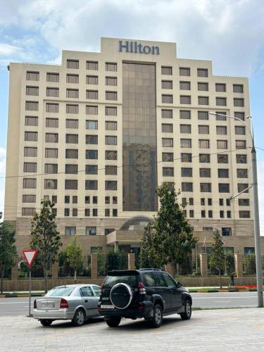 a limo parked in front of a hilton hotel at Апартаменты рядом с Hilton in Dushanbe