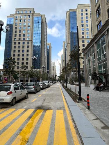 a city street with parked cars and buildings at Апартаменты рядом с Hilton in Dushanbe