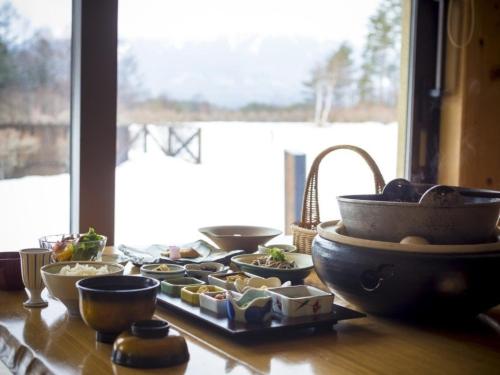 木曽町にあるつたや季の宿　風里の食べ物の入ったボウルや皿が置かれたテーブル