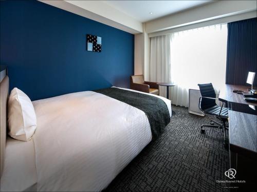 a hotel room with a large bed and a desk at Daiwa Roynet Hotel Chiba Ekimae in Chiba