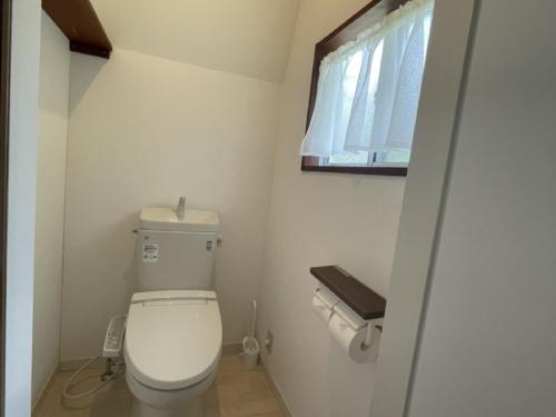 a small bathroom with a toilet and a window at Mt Fuji view! Cottage JOKIGEN House F in Yamanakako