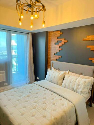 a bedroom with a large bed and a chandelier at Azure North Beach View New Unit Rustic Suite in Lagundi
