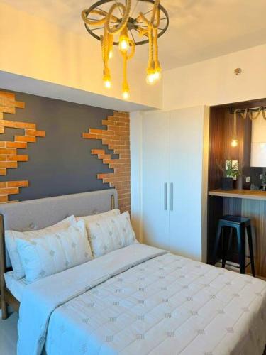 a bedroom with a large white bed and a chandelier at Azure North Beach View New Unit Rustic Suite in Lagundi