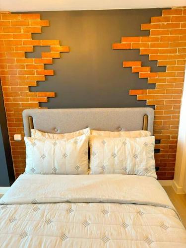 a bed in a bedroom with a brick wall at Azure North Beach View New Unit Rustic Suite in Lagundi