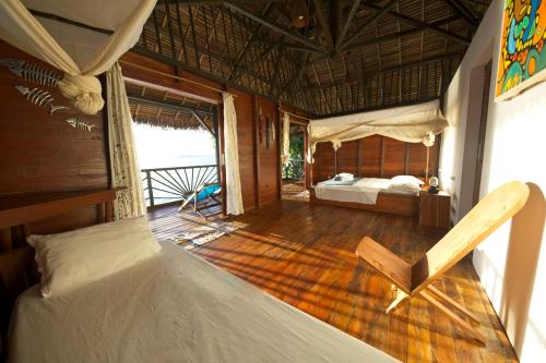 Nosy Komba的住宿－Nosy Komba Lodge，一间设有一张床的客房和一间设有一张床铺的卧室
