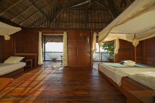 Nosy KombaにあるNosy Komba Lodgeのベッド2台が備わるウッドフロアの客室です。