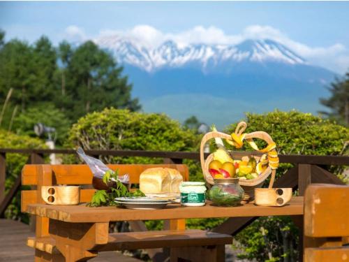 木曽町にあるつたや季の宿　風里の果物のバスケットと山が描かれたピクニックテーブル