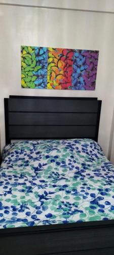 une chambre avec un lit et un tableau au mur dans l'établissement Iloilo Condominiums, à Iloilo