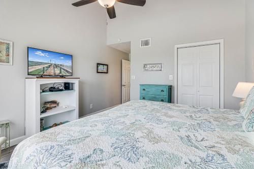 a bedroom with a large bed and a ceiling fan at Bayfront Kontiki in Rockport