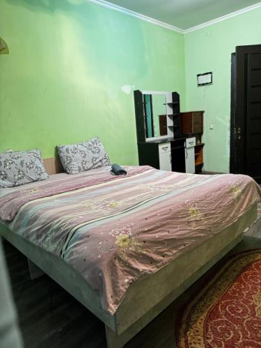 a bedroom with a large bed with a pink blanket at Тимур in Bishkek