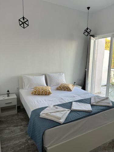 a bedroom with two beds and a window at Pefki apartments in Limenaria