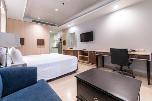 a hotel room with a bed and a desk with a computer at Admiral Premier Bangkok in Bangkok
