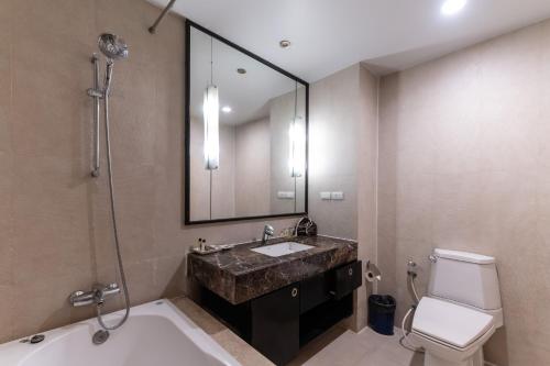 a bathroom with a sink and a tub and a toilet at Admiral Premier Bangkok in Bangkok