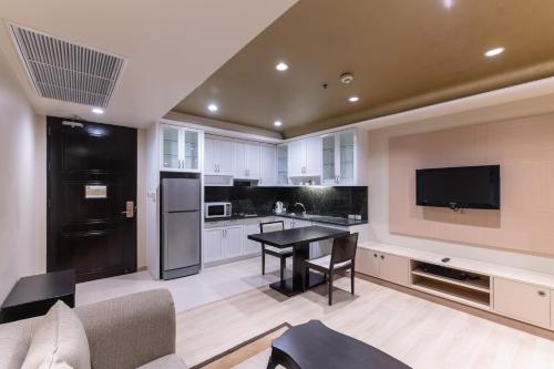 a living room with a table and a kitchen at Admiral Premier Bangkok in Bangkok