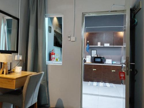 BRICKS Cameron Hostel في تاناه راتا: غرفة مع طاولة ومطبخ مع مكتب