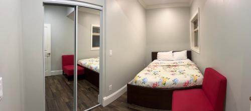 Dormitorio pequeño con cama y espejo en Spacious !!! NEWER HOME 2 bedrooms Entire suite !! Near Airport !!!! en Abbotsford