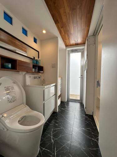 a bathroom with a toilet and a sink at KATSUREN Blue. in Uruma