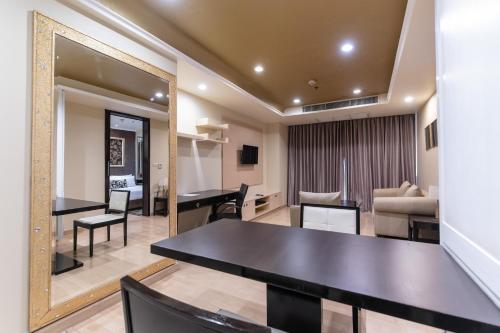 a living room with a table and a mirror at Admiral Premier Bangkok in Bangkok