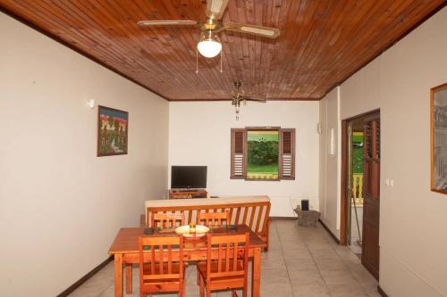 a dining room with a table and chairs and a ceiling at Maison charmante à Gros-Morne avec terrasse et jardin in Gros-Morne