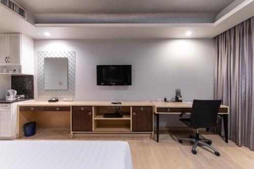 an office with a desk and a television on a wall at Admiral Premier Bangkok in Bangkok