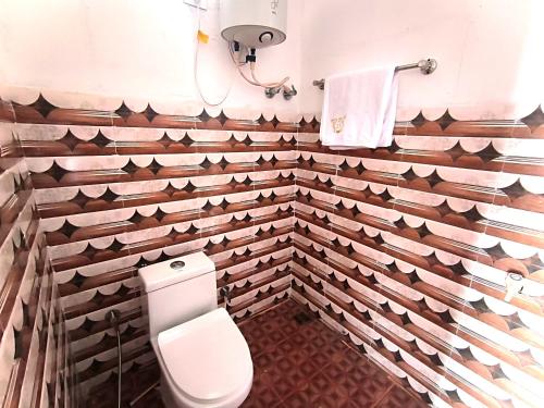 baño con paredes de madera y aseo en L.T NATURE GLAMPS, en Kodaikanal