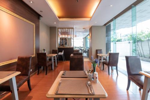 a restaurant with tables and chairs and a large window at Admiral Premier Bangkok in Bangkok