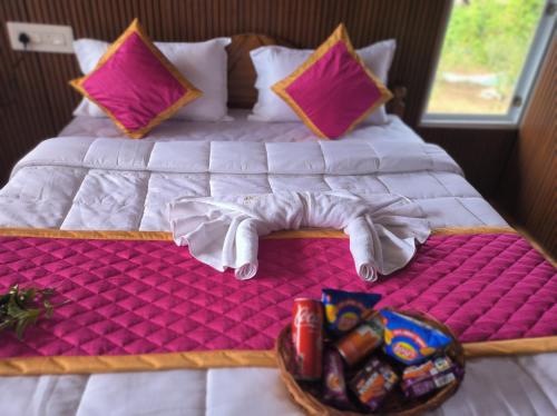 a bed with two hands and a tray of food at L.T NATURE GLAMPS in Kodaikānāl