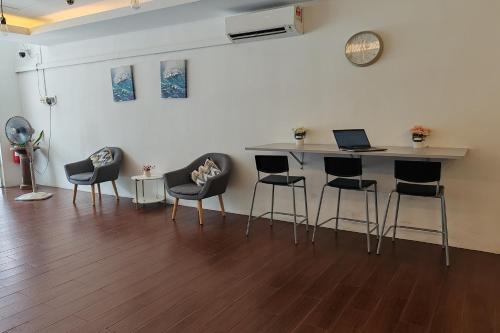 a bar with chairs and a table with a laptop on it at Hotel 18 Ipoh Aeon Mall in Ipoh