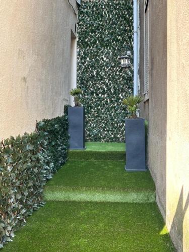a wall with two potted plants on the side of a building at Le coup de c’Heurt duplex 100m de la mer 8 personnes in Le Portel