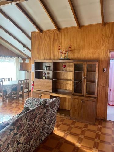 a living room with a couch and a entertainment center at Cabañas Español Coyhaique in Coihaique