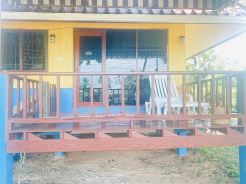 um alpendre de uma casa com uma cadeira em Aforetime House @ Samui em Taling Ngam Beach