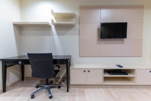 a desk with a chair and a television in a room at Admiral Premier Bangkok in Bangkok