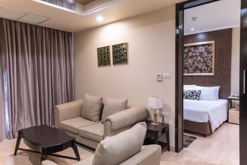 a hotel room with a couch and a bed at Admiral Premier Bangkok in Bangkok