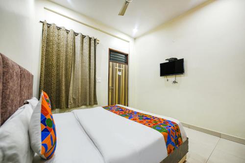 1 dormitorio con 2 camas y TV. en FabExpress Galaxy en Chandigarh