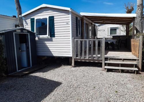un mobil-home avec un porche et une rampe en bois dans l'établissement Europcamping Mobil-home Climatisé, à Fréjus